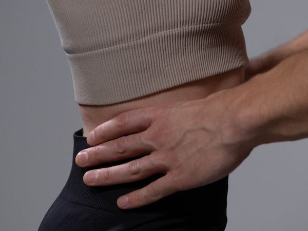 A gentle back stretch movement shown from the side.